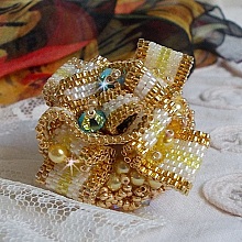 Bague Sunflower Gold brodée d’un ruban que j’ai mis en forme avec des rocailles plaquées or 24 carats, perles nacrées en cristal, toupies, perle ronde nacrée. Le tout est monté sur une bague Dorée
